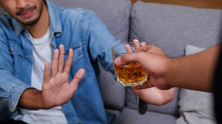 мужчина отказывается от бокала с алкоголем