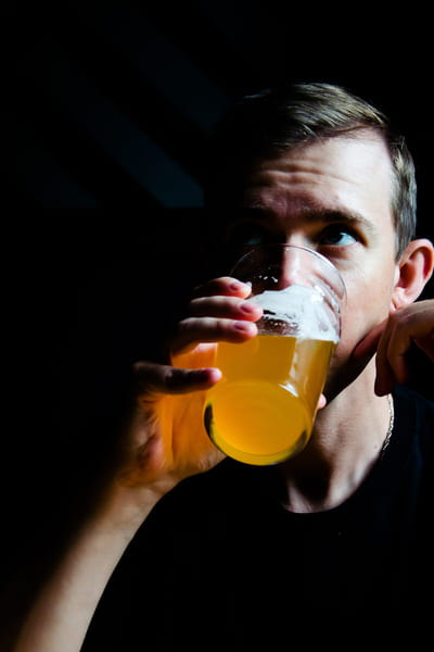 Мужчина пьет пиво из бокала